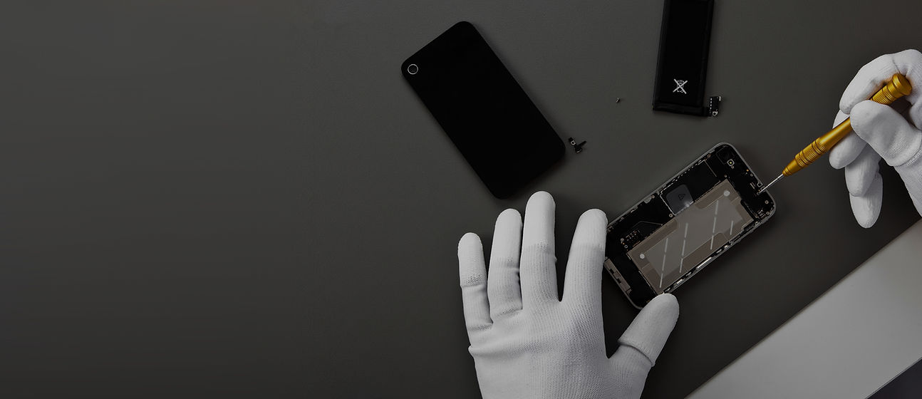 Hands wearing white gloves repairing a smartphone