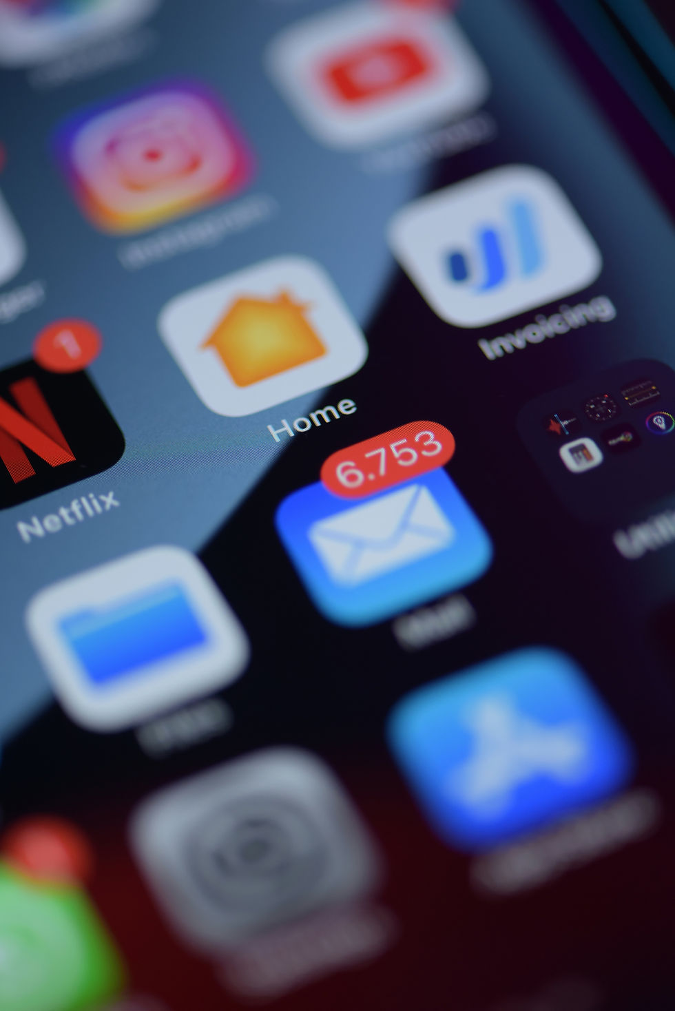 Close-up of a smartphone screen showing app icons. The email app has 6,753 unread messages. Notable apps: Netflix, Home, Instagram.