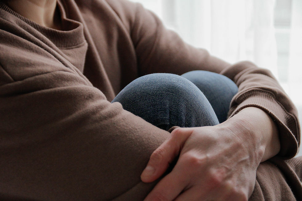 Person holding legs to chest