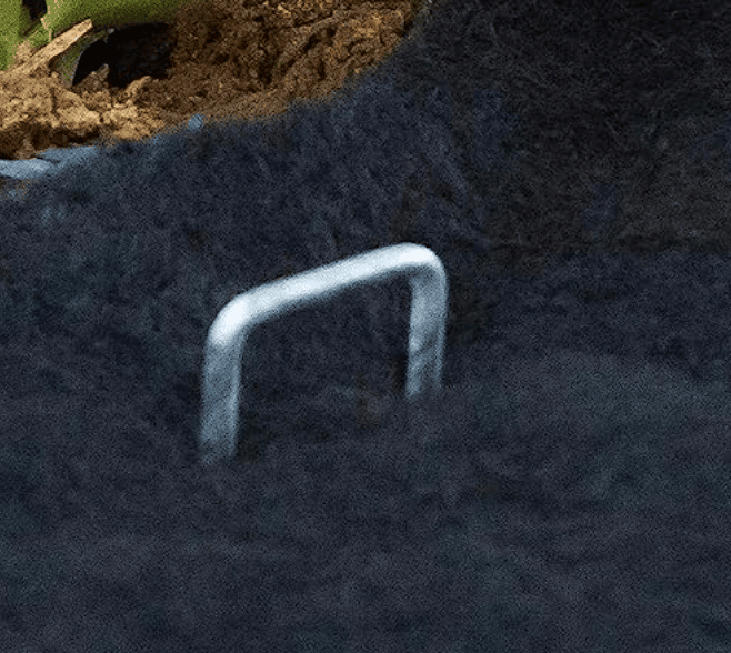 Thumbnail: galvanized landscape staples securing weed barrier fabric in garden bed