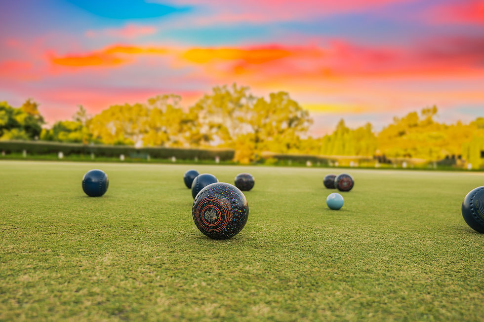 Lawn bowls and Jack sitting on the green during sunset