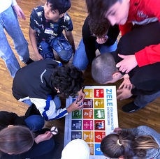 Nachhaltige Entwicklungsziele, Kinder an einem Poster am arbeiten und lernen