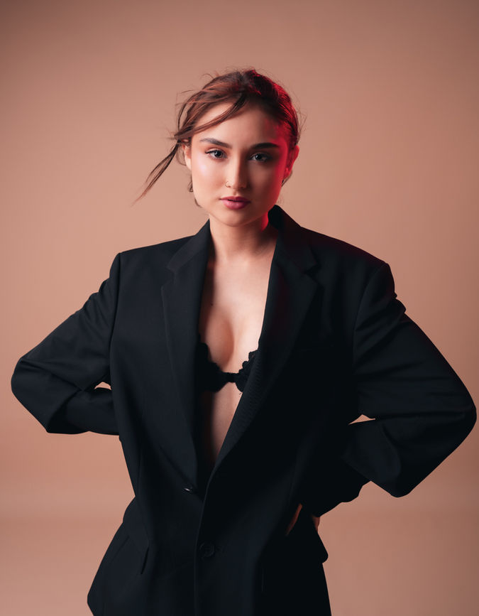 Fotografía de mujer con lencería y blazer negro en estudio beige, editorial íntima y sofisticada por Kevin Reyes