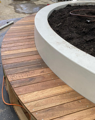 Curved bench seat around planter box.