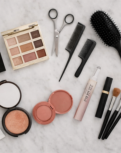 Selection of cosmetics and hairstyling tools on marble surface
