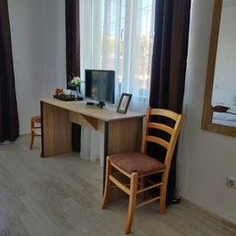 Cameră cu birou, monitor, două scaune și oglindă