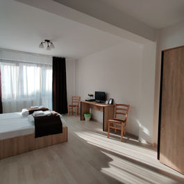 Cameră luminoasă cu pat dublu, birou și dulap.