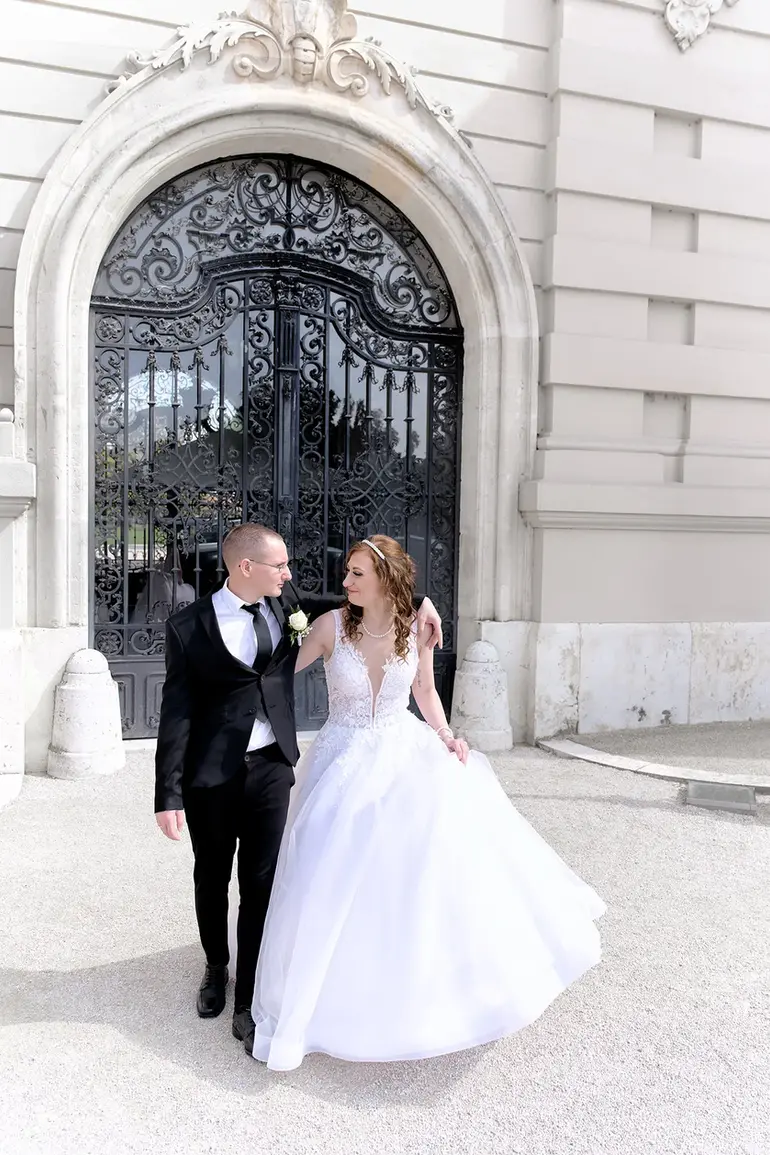 sétáló esküvőipár a keszthelyi Festetics kastély előtt
