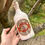 Thumbnail: Orkney Gin Company K-Ola Old Tom bottlebeing held by hand in trees