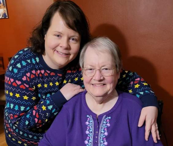 Smiling caregiver with an elderly woman, caregiver self-care