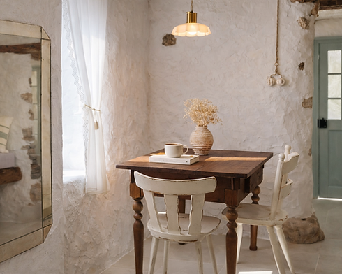 Dining area with wooden table and natural light in a rustic guesthouse in the Soča Valley