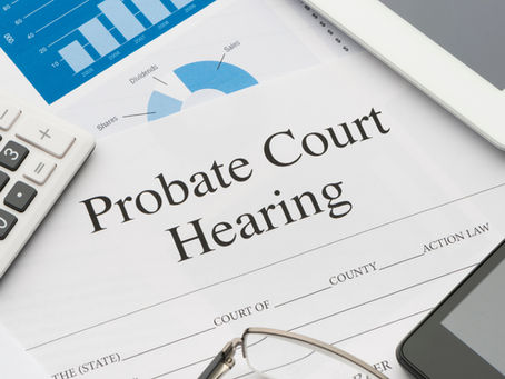 A paper that states "probate court hearing". There are papers under it and a calculator and tablet on the corners.