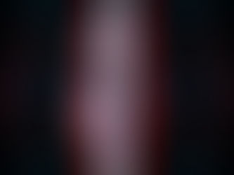 The image depicts a woman's face centrally, bisected by a bright vertical beam of light that transitions from red on the left to blue on the right. Her eyes are open and looking forward. Surrounding her face is a dark background filled with what appears to be digital code or data, predominantly in shades of red and blue, suggesting a digital or virtual environment. Red, glowing lines and numerical readouts form a reticle-like or targeting overlay, especially around the edges of the image, further emphasizing a technological or surveillance theme. The overall impression is one of digital immersion, data, and perhaps a futuristic or cybernetic context.