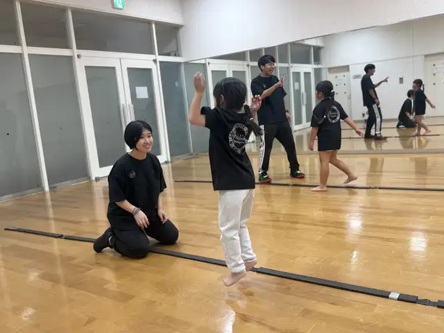 笑顔のコーチとリズムトレーニングをする子どもたち（大阪茨木校）