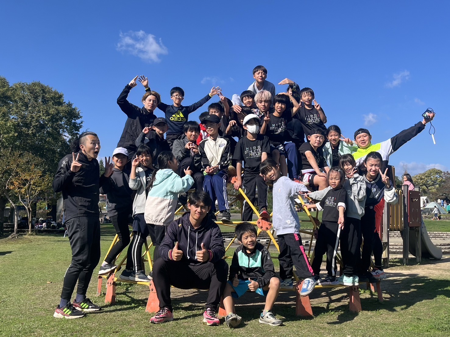 笑顔で集合写真を撮るイベント参加者とコーチたち