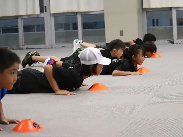 うつ伏せからのスタートに備える子どもたち（京都伏見校）