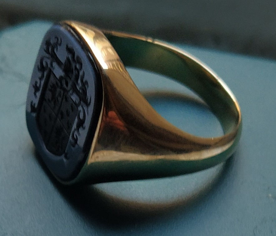 Thumbnail: anillo de oro con escudo grabado en agata bicolor