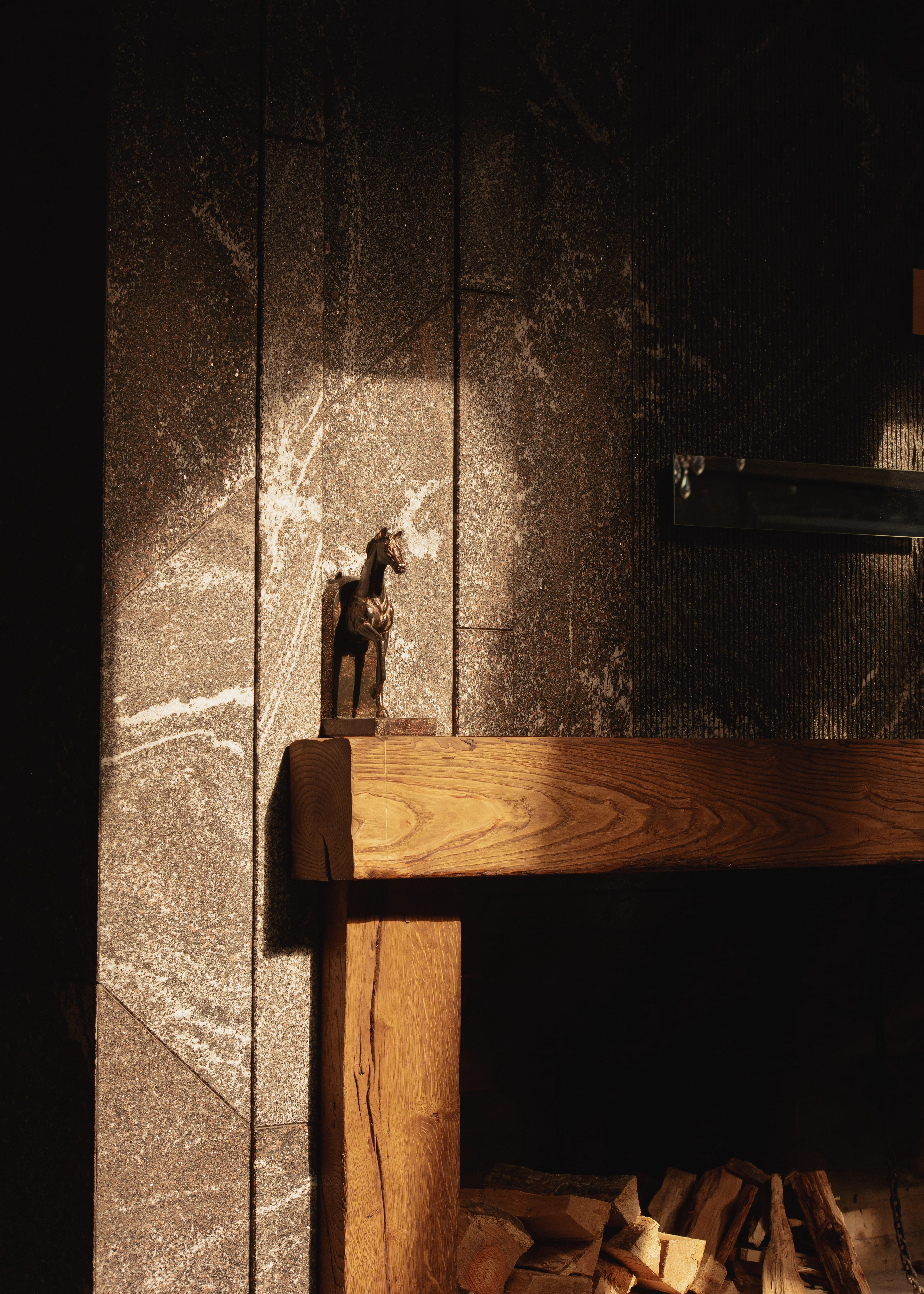 Cozy fireplace corner with warm light, textured wall, wood elements and soft shadows creating intimate atmosphere, interior mood lighting, угол с камином, теплый свет и текстуры создают атмосферу уюта, rincón con chimenea, luz cálida y sombras suaves creando ambiente íntimo