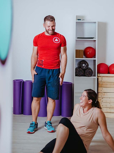 coach débout qui rigole avec une femme assise