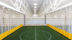 Yellow walk draw divider curtain inside of an indoor sports facility.