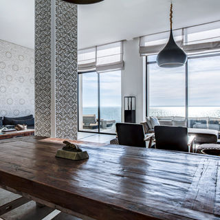 Salle de repos avec grande baie vitrée et vue lagon.