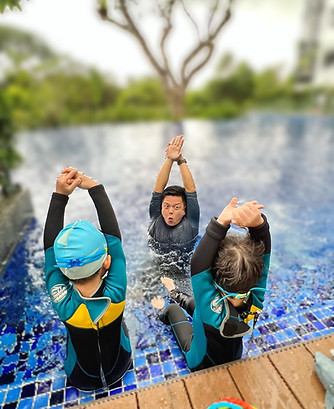 A friendly Swim Monkey instructor teaching water safety to a young child in a Singapore pool.