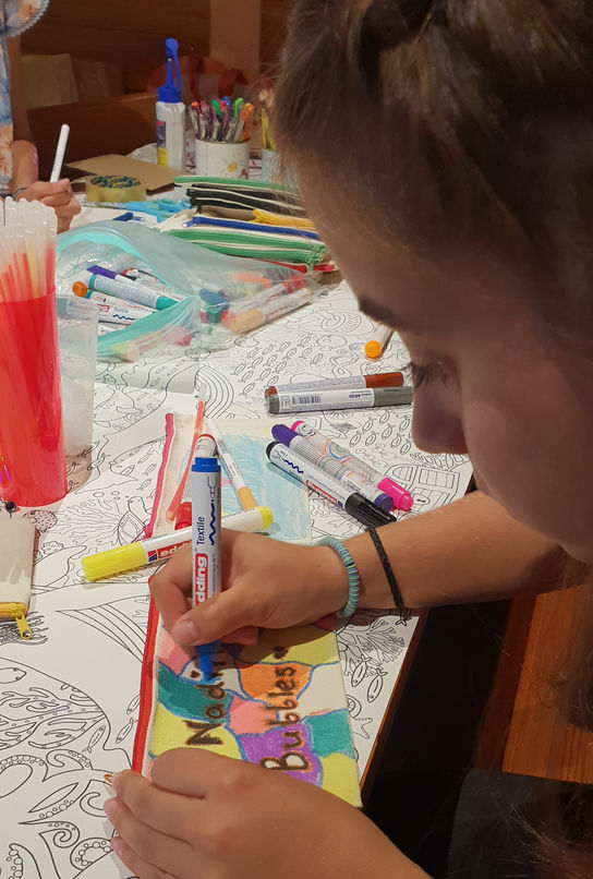 Ein Kind ist konzentriert, mit einem Filzstift^am basteln.