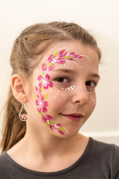 Ein Mädchen mit geschminkten Blumen im Gesicht