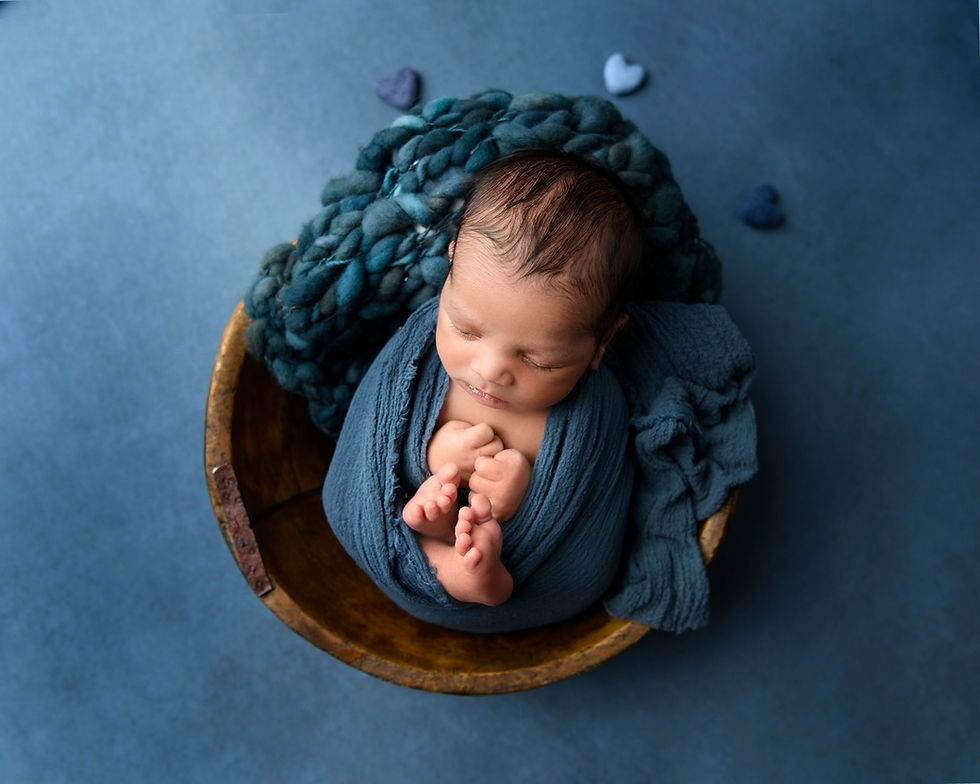 Newborn in a bowl with hearts