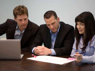 Small business team reviewing AI opportunities together on a laptop.