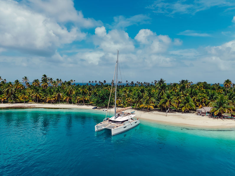Isla de San Blas con palmeras, arena blanca y un catamarán fondeado en aguas turquesas