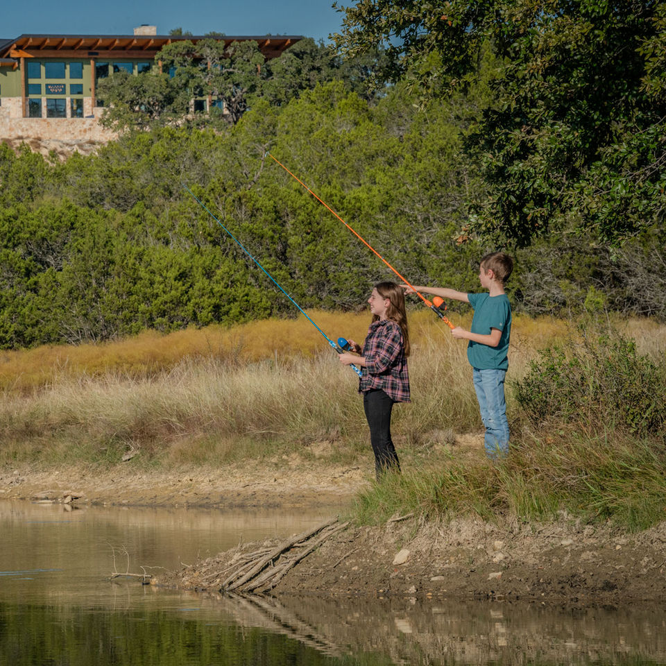 Parents teach children how to fish on ranch vacation