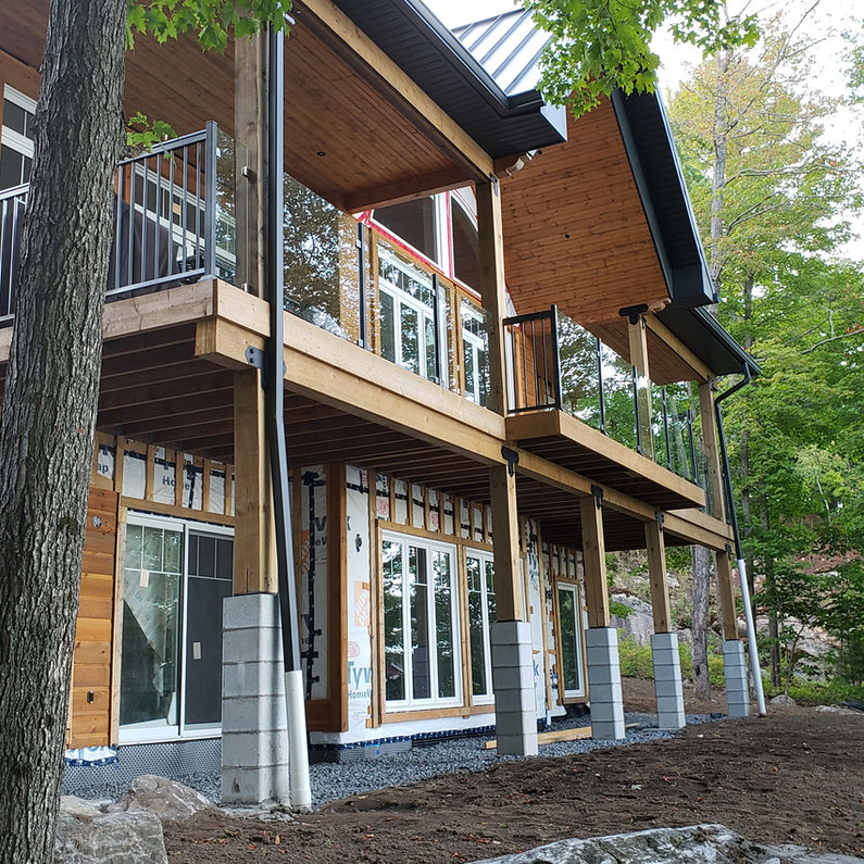 Multi-level house with wood siding, decks, and aluminum railings
