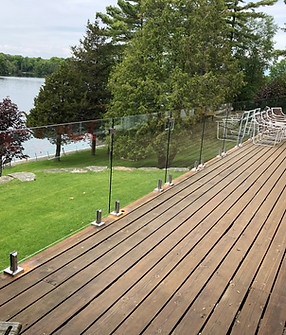 Frameless Glass Railings with spiggots installed on wood deck in Barrie