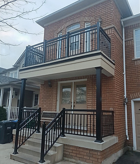 black aluminum columns supporting balcony above porch entracnce