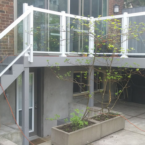 White aluminum railings with glass panels on deck