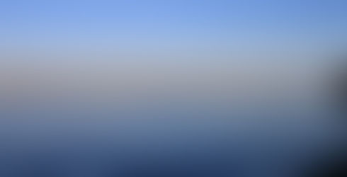 Calm river scene with sailboat, clear blue sky