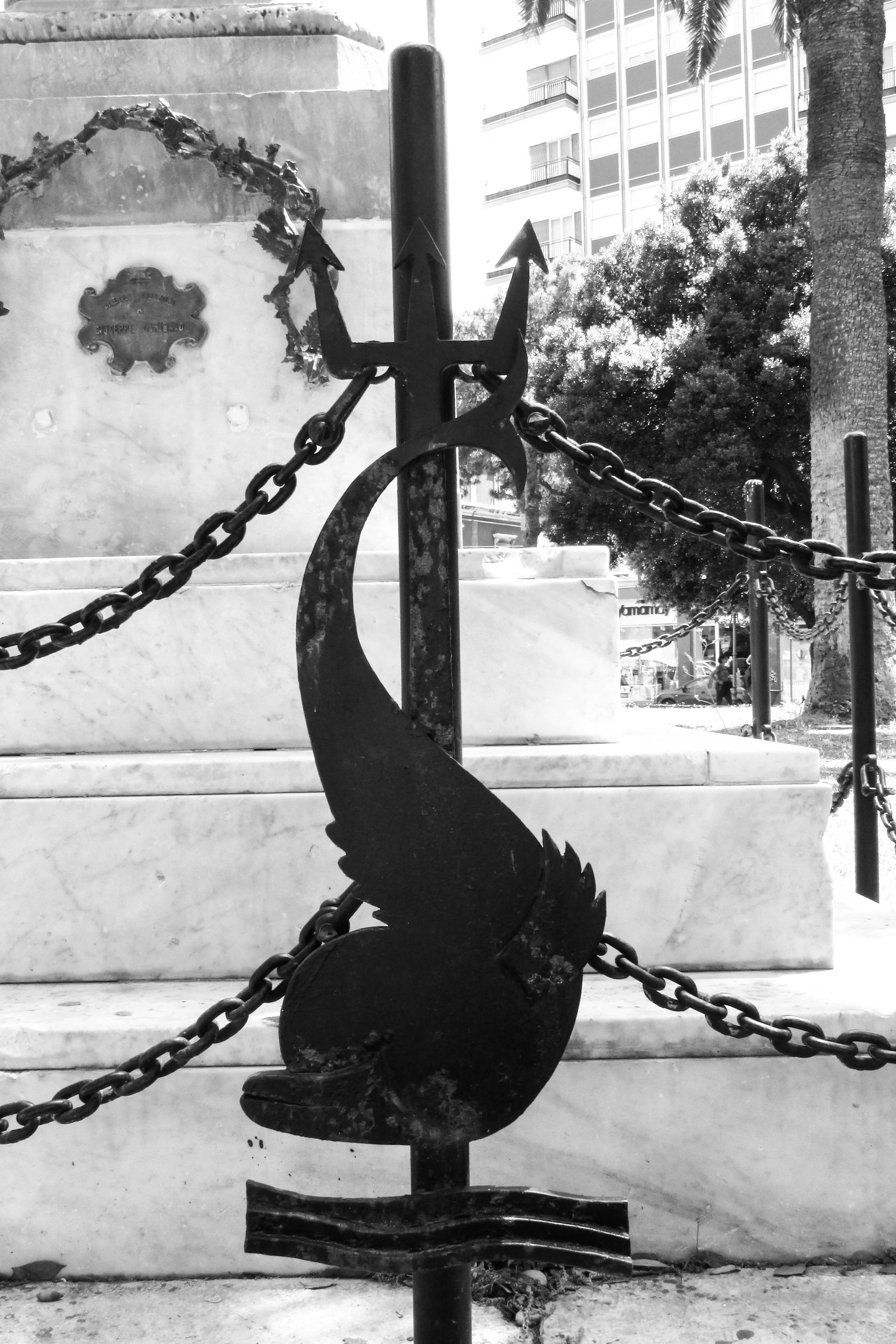 Black metal dolphin sculpture with chains
