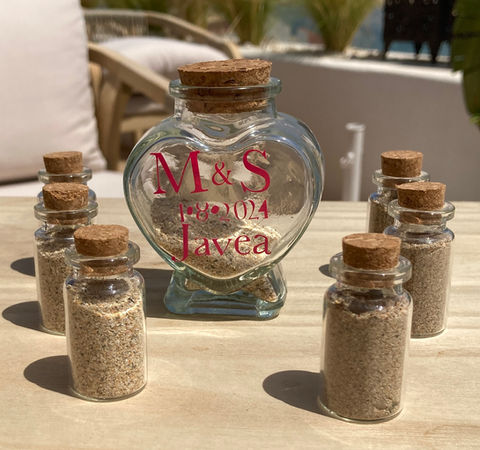 Bride and Groom our coloured blue and white sands alternatively into a glass bottle to create a layered sand effect in this unity ritual