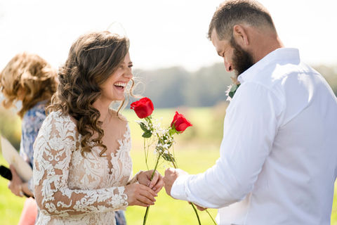 Bride and groom exchange red stemmed roses in a wedding ritual in Spain