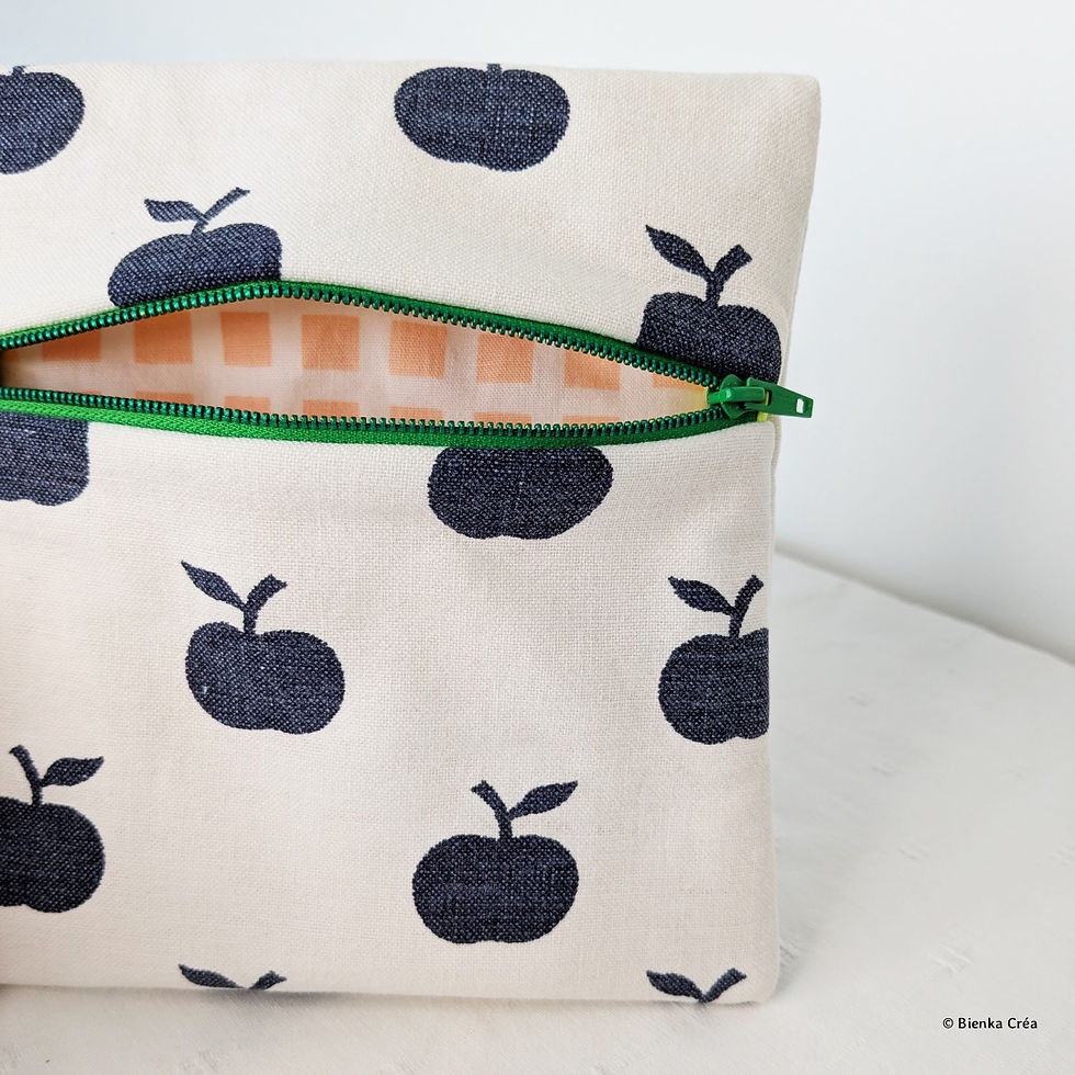 Vue de l'intérieur d'une trousse carrée doublée en coton écru à motifs pommes bleues fermée par un zip vert
