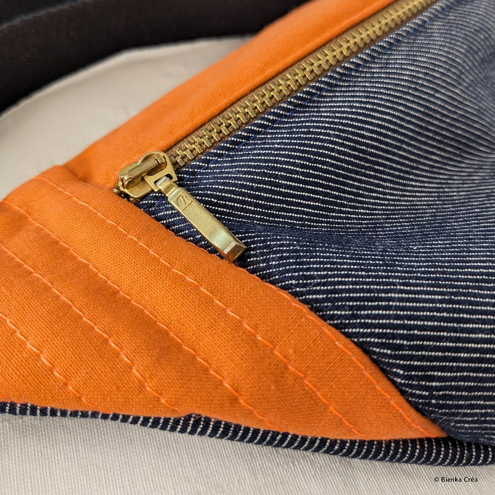 Gros plan du zip vintage marron d'un sac banane bleu et orange à bandoulière noire
