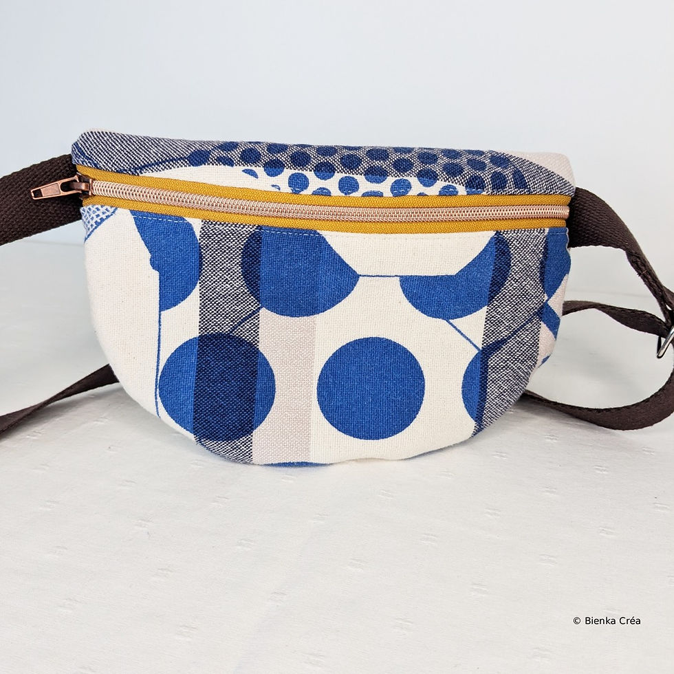 Vue d'un petit sac banane en coton tissé à pois bleus fermé par un zip jaune moutarde