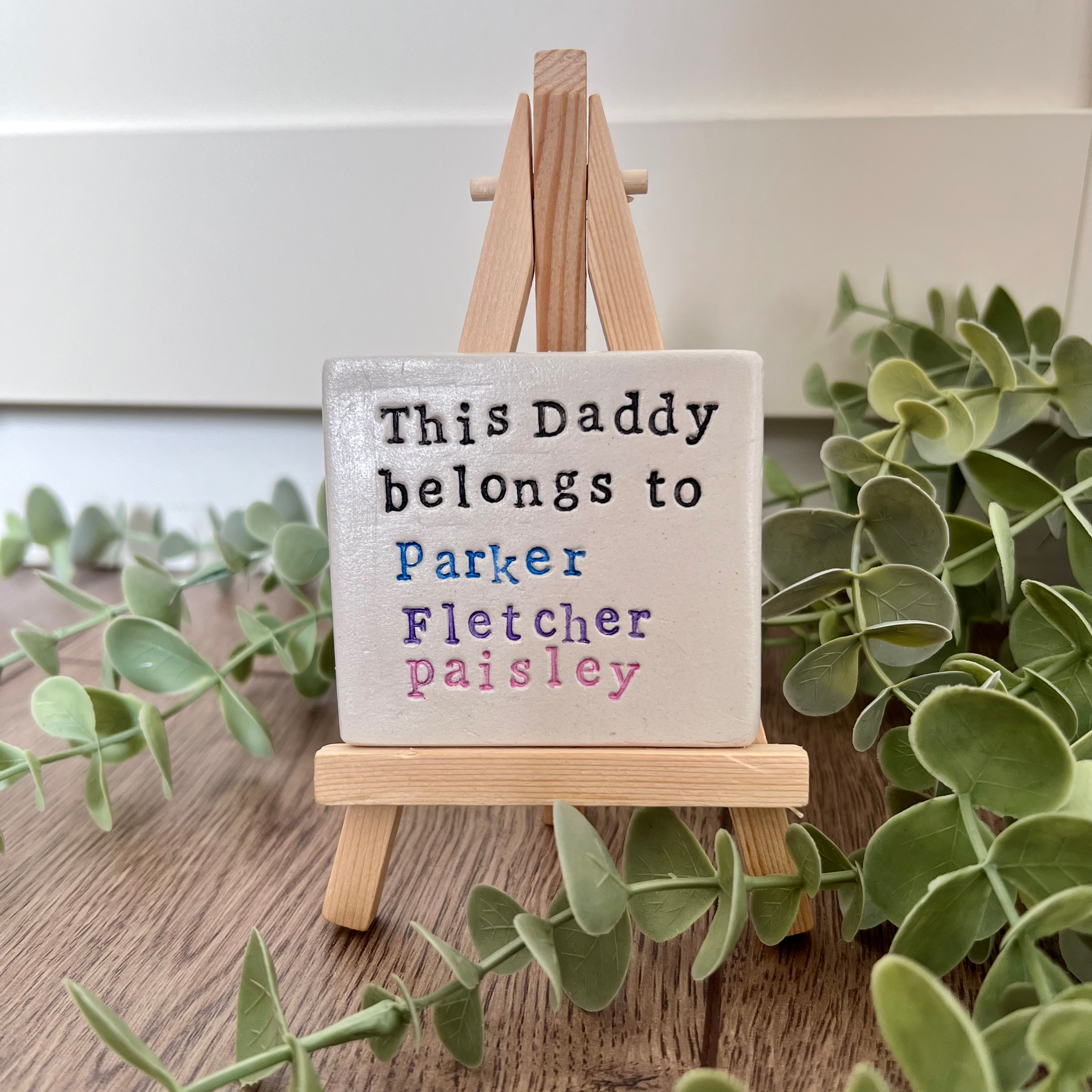 Mini clay plaque on a wooden easel, saying "This Daddy belongs to", and children's names