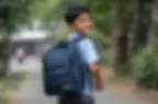 school boy with backpack smiling at camera