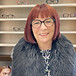 lady with red hair wearing black upswept glasses
