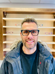 happy Banks Opticians client, a man wearing large bold and black frames that are square on his face