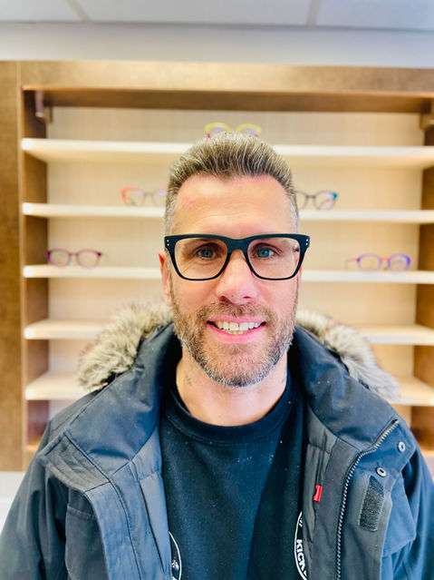 happy Banks Opticians client, a man wearing large bold and black frames that are square on his face