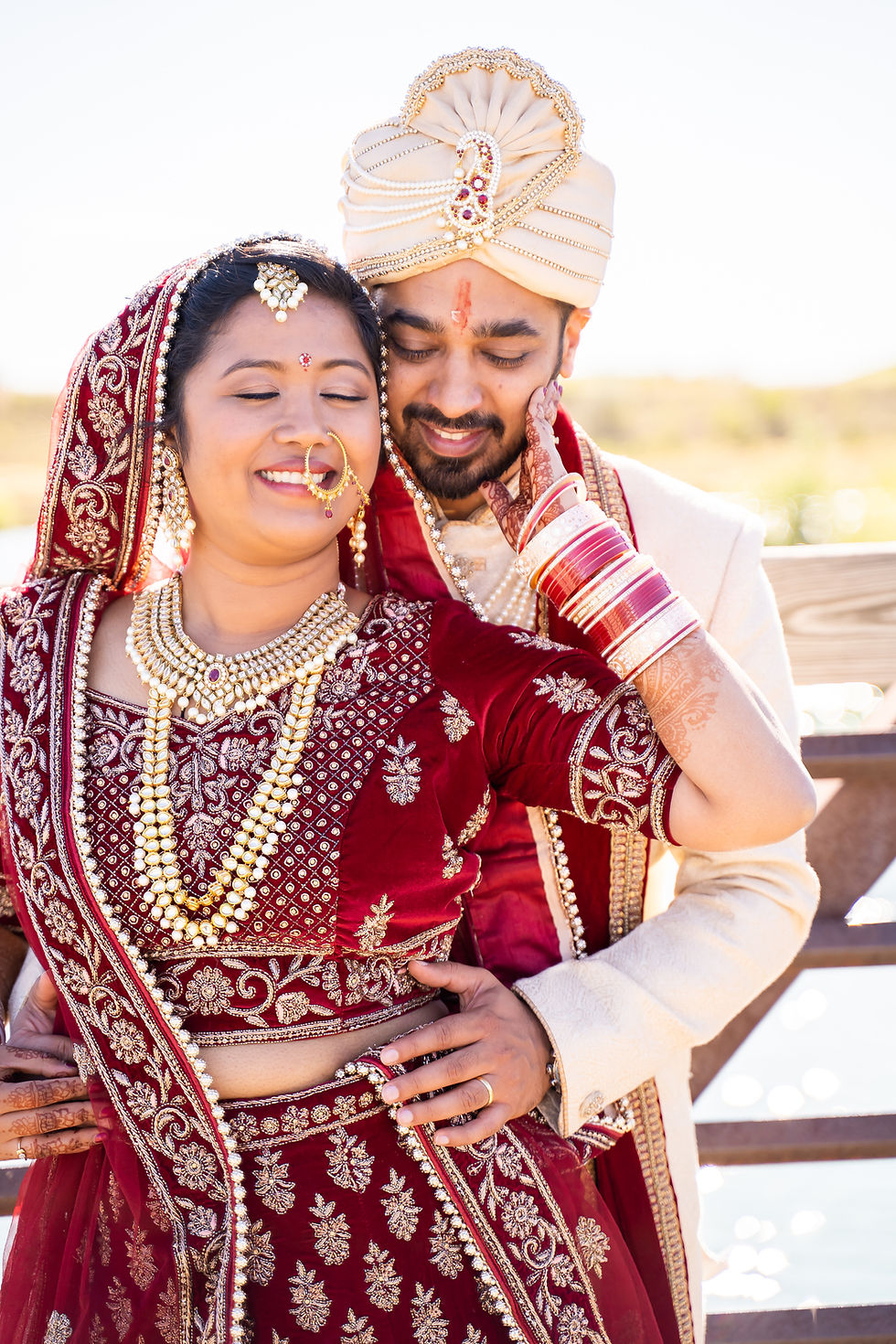 Indian wedding photographer captures image of indian husband and wife holding each other smiling.