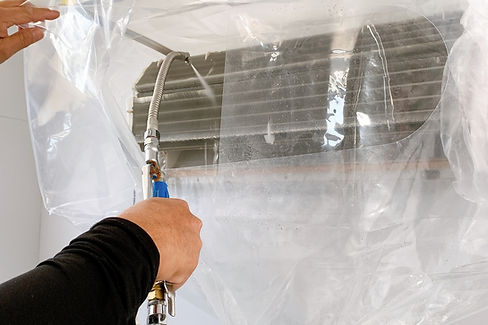 エアコンを高圧洗浄作業中